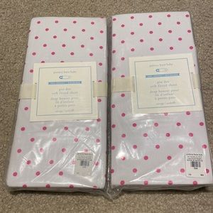 Pair of pottery barn fitted crib sheet.  White with pink polka dots